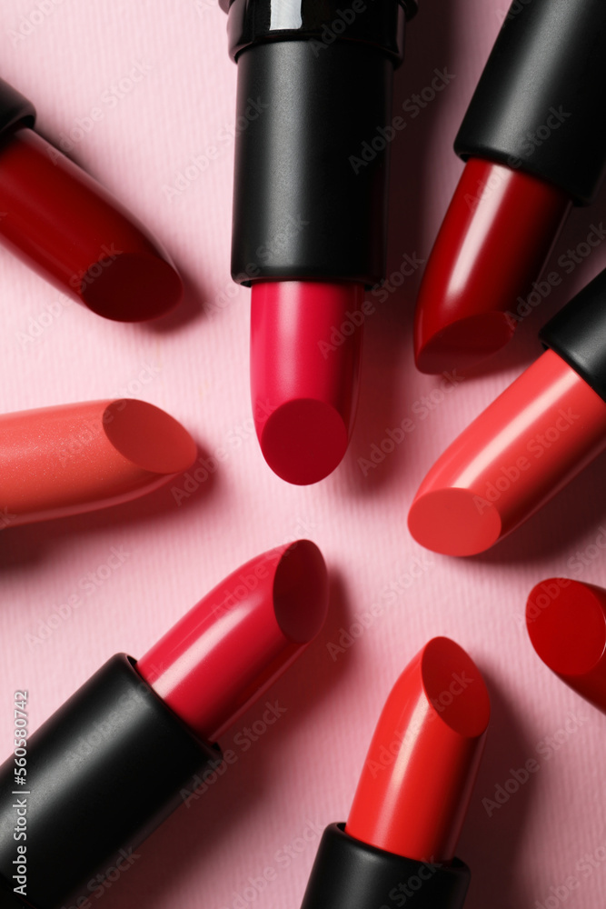 Obraz premium Many bright lipsticks on pink background, flat lay