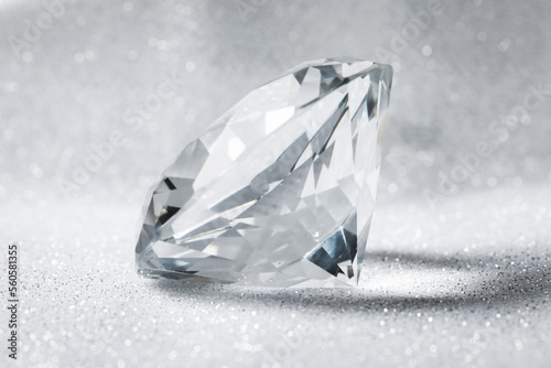 Beautiful dazzling diamond on shiny glitter background  closeup. Precious gemstone