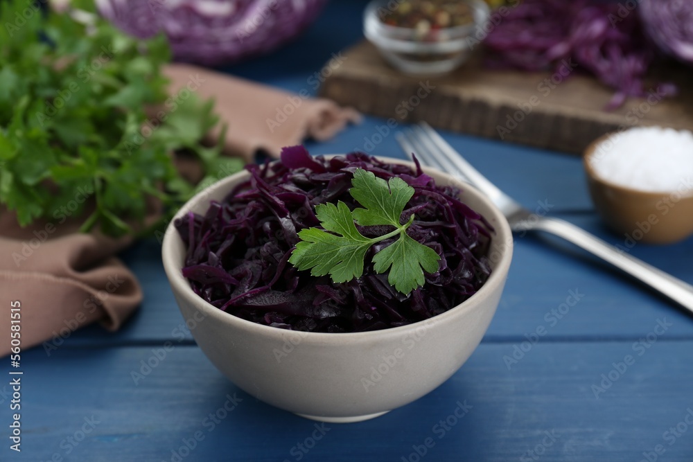 Tasty red cabbage sauerkraut with parsley on light blue wooden table Tasty red cabbage sauerkraut with parsley on light blue wooden table
