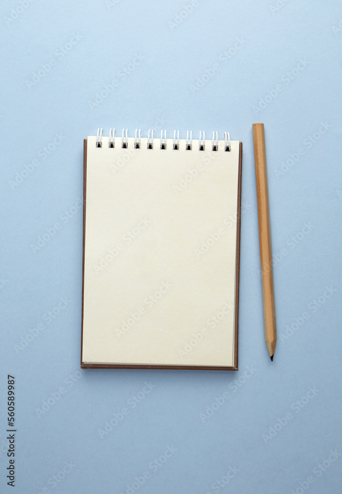 School notebook with pencil on a blue background School notebook with pencil on a blue background