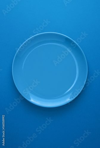 Top view of blue color plate isolated on blue background