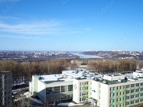 Urban landscape, modern buildings, frozen river and blue sky. © Ольга Кожина