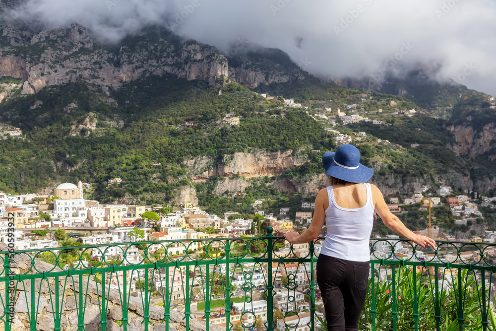 Woman tourist at a touristic town, Positano, by the Tyrrhenian Sea. Amalfi Coast, Italy. Nature Background. Adventure Travel