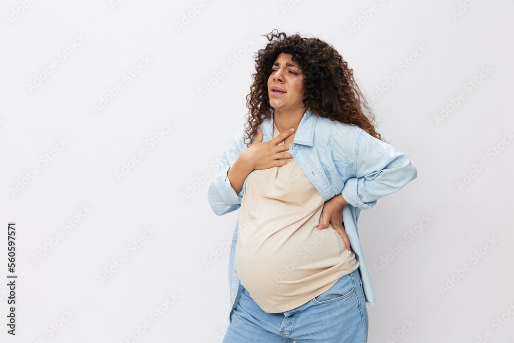Pregnant woman tired, headache and abdominal pain, heavy pregnancy, last month before childbirth on white isolated background in T-shirt with blue shirt Pregnant woman tired, headache and abdominal pain, heavy pregnancy, last month before childbirth on white isolated background in T-shirt with blue shirt