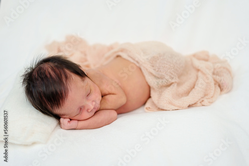 newborn baby sleeping in blanket on bed