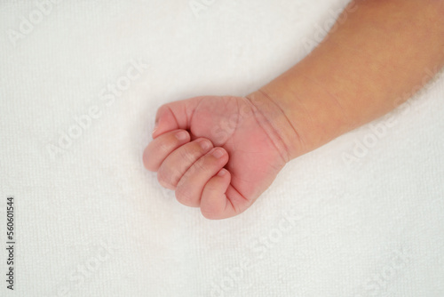 Close up newborn baby hand on bed