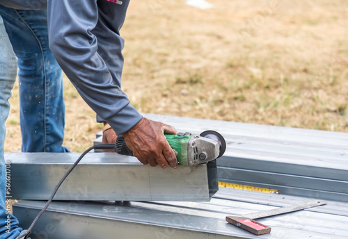 Closeup of construction workers' hands cutting steel.