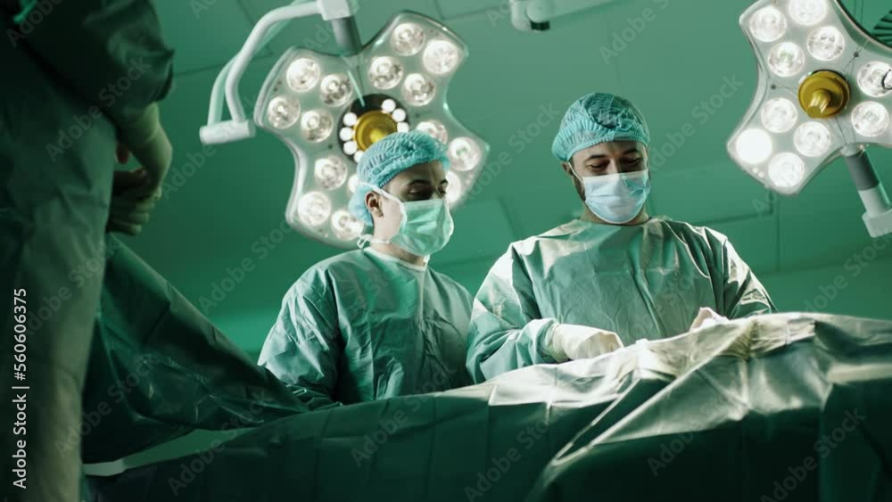 Professional doctors performing operation in surgery room.
