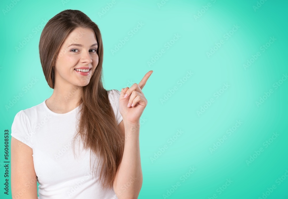 Happy young girl pointing finger on color background Happy young girl pointing finger on color background