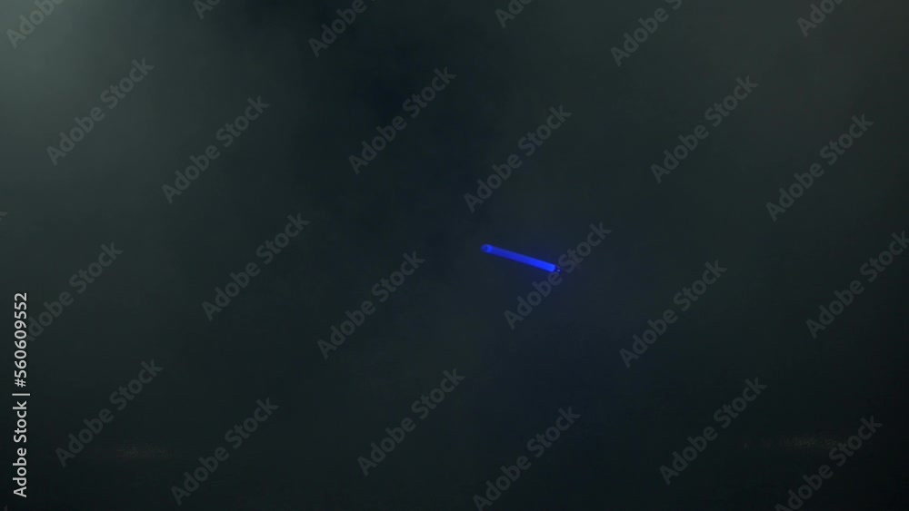 Young man in Jedi cosplay costume with lightsaber battle on black background in smoke and rain, 4k slow motion video filmed on 8k camera nikon z9