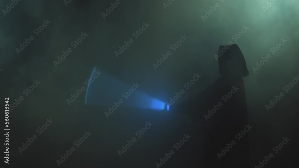 Young man in Jedi cosplay costume with lightsaber battle on black background in smoke and rain, 4k slow motion video filmed on 8k camera nikon z9