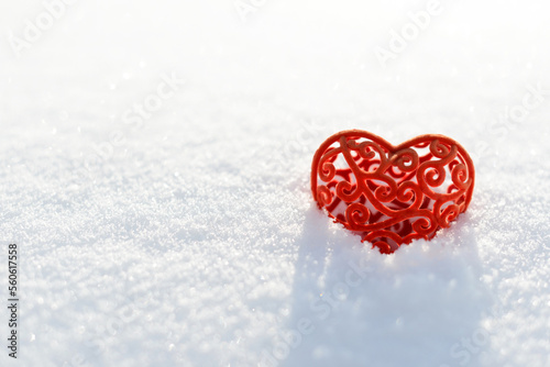 Valentine in snow. Red velvet heart  symbol of romantic love on a snowy background or snowdrift  concept of Valentines day