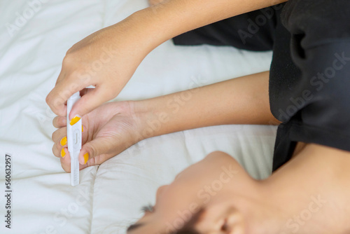 Woman hands holding ovulation test in bed