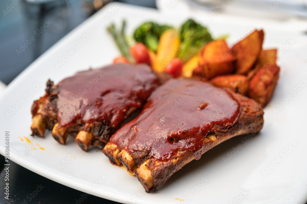 Grilled pork ribs topped with special marinade bbq sauce, french fries and vegetable