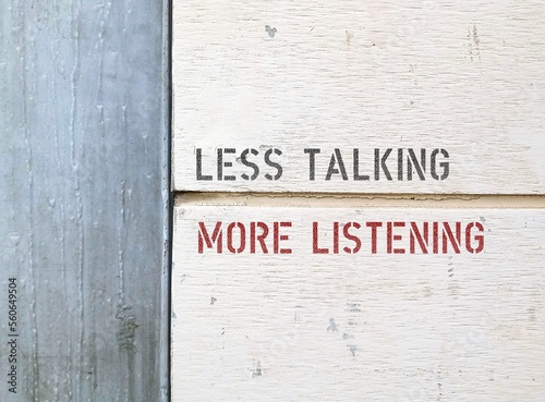 Line on wall separating two parts with text LESS TALKING MORE LISTENING,  to speak less and listen more , learn from people’s stories- stop talking too much and leave space for others to speak