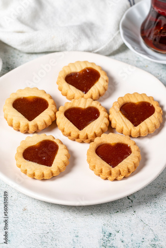 Heart shaped cookies on plate on gray background. Cookies with marmalade filling in the middle. Bakery desserts. close up