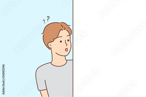 Astonished man feel frustrated looking from around corner 