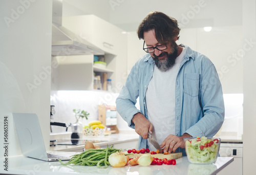 One man alone at home preparing lunch in the kitchen. Healthy lifestyle people cutting vegetables to prepare a light salad. Indoor leisure activity. Living single concept. Husband working for wife