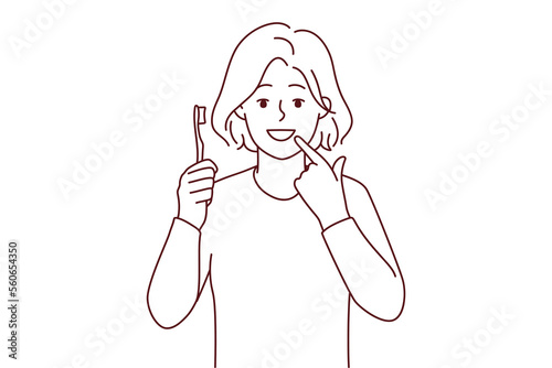 Smiling girl with toothbrush show at white clean teeth. Happy child recommend teeth brushing and oral care. Dental care concept. Vector illustration. 