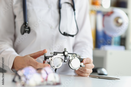 Ophthalmologist with trial frame for selection of complex astigmatic glasses photo