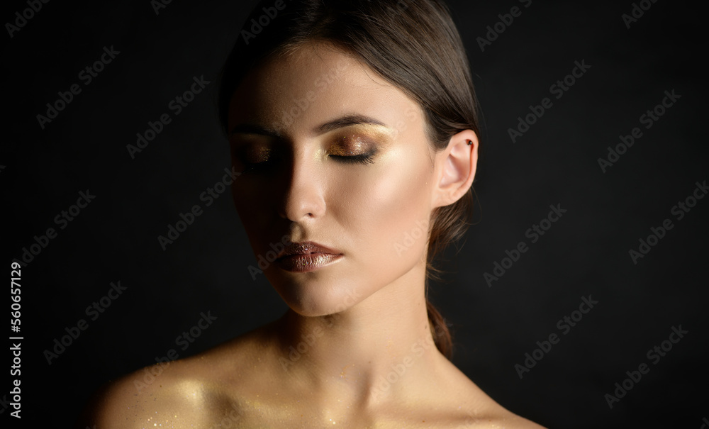 Fototapeta premium Close-up portrait of young woman with golden makeup.