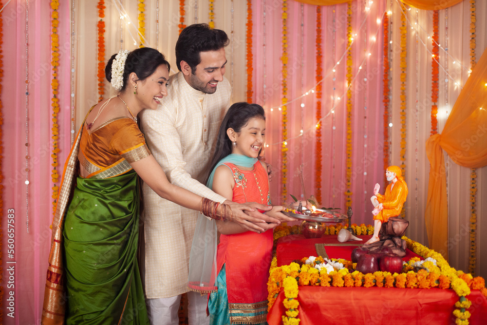 Indian family performing Sai Baba pooja at home. Family dressed in