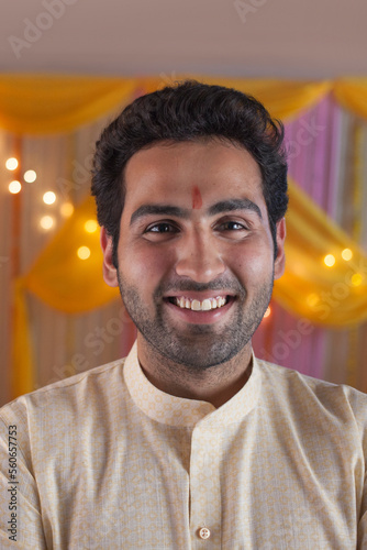 Young man with beard / stubble - wearing kurta pyjama with smiling face. Indian man wearing kurta pajama with a tilak on forehead carrying ethnic look for the festive season - Diwali / Durga Puja photo