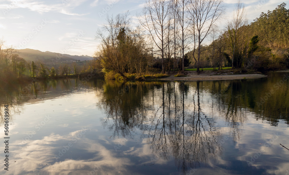 Bonito recodo de un río en el que se reflejan los árboles y las nubes en sus aguas. Molleda, Asturias, España.