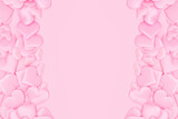 Border frame made of textile hearts confetti on a pink background. Monochrome concept with place for text.