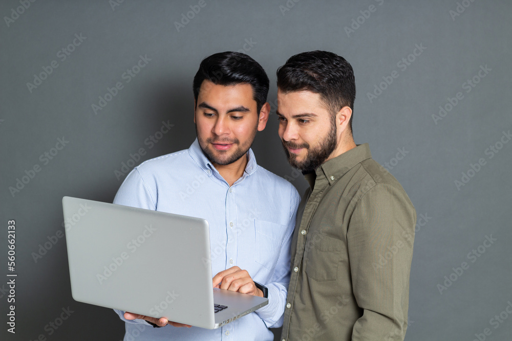 young men in office watching sales report on laptop young men in office watching sales report on laptop