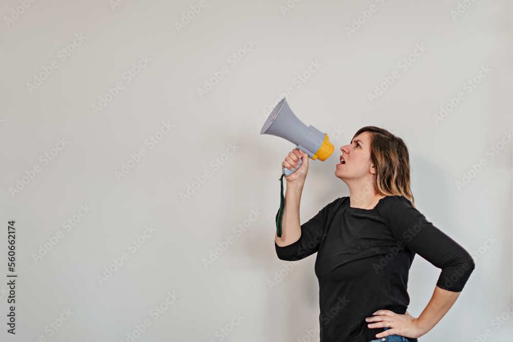 angry woman shouting upwards through a loudspeaker angry woman shouting upwards through a loudspeaker