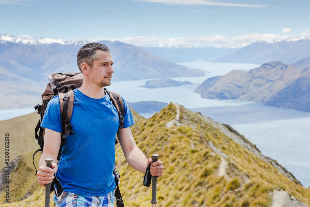 Young man standing on top of cliff in summer mountainsand enjoying view of nature Young man standing on top of cliff in summer mountainsand enjoying view of nature