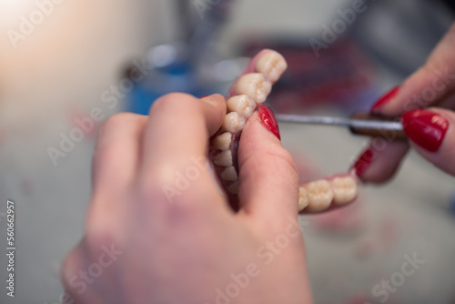 Dental technician works by brush with jaw model. Facial Dental Prosthetic
