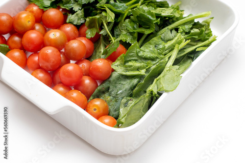 Fresh red cherry tomatoes and parsley leaves