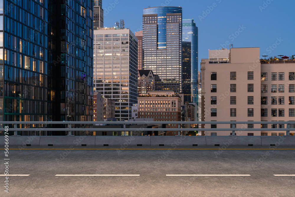 Empty urban asphalt road exterior with city buildings background. New modern highway concrete construction. Concept of way to success. Transportation logistic industry fast delivery. Los Angeles. USA. Empty urban asphalt road exterior with city buildings background. New modern highway concrete construction. Concept of way to success. Transportation logistic industry fast delivery. Los Angeles. USA.