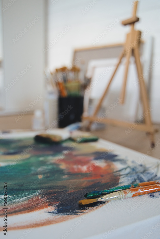 Brushes with canvas on working studio background. Vertical image. Brushes with canvas on working studio background. Vertical image.