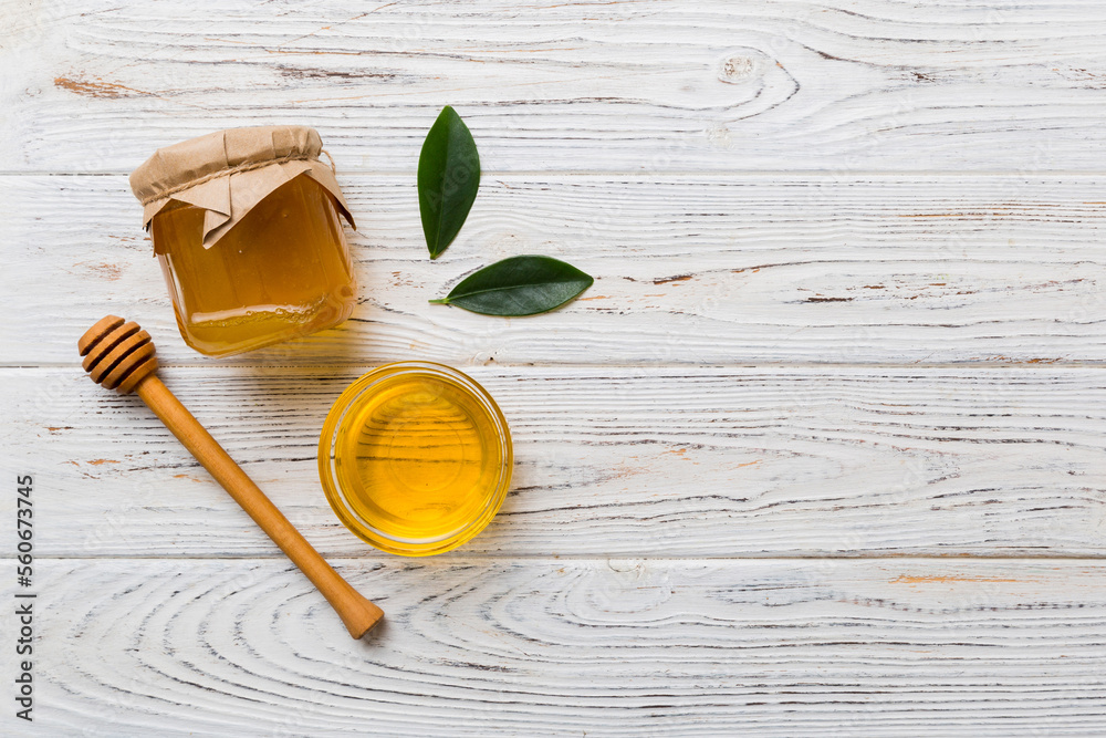 Honey jar with wooden honey dipper on white background top view with copy space. Delicious honey bottle Honey jar with wooden honey dipper on white background top view with copy space. Delicious honey bottle