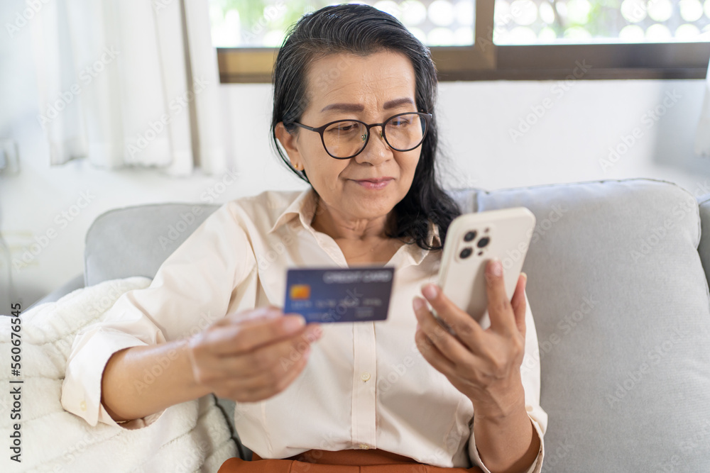 Senior woman with smart phone for online shopping. Hand holding mobile phone with Payment on credit card online shopping electronic wallet Payment Shopping by phone and connected card concept Senior woman with smart phone for online shopping. Hand holding mobile phone with Payment on credit card online shopping electronic wallet Payment Shopping by phone and connected card concept