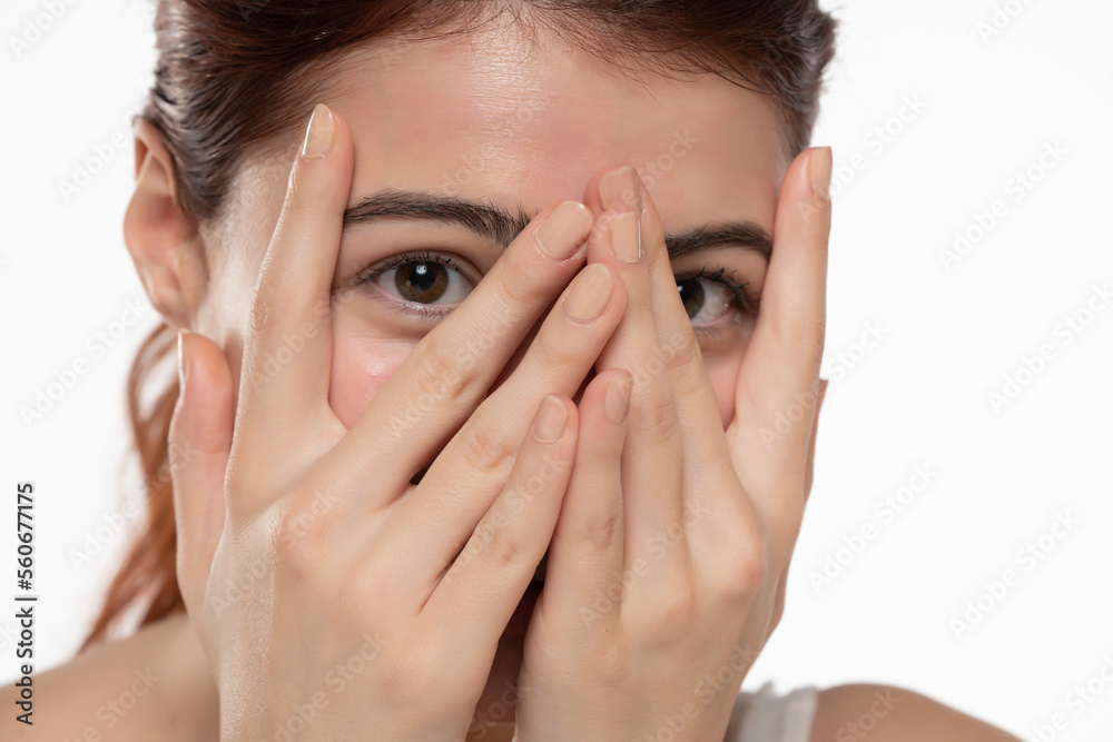Portrait of yong happy ashamed woman, covering face with hands, beautiful model posing in studio over white background Portrait of yong happy ashamed woman, covering face with hands, beautiful model posing in studio over white background