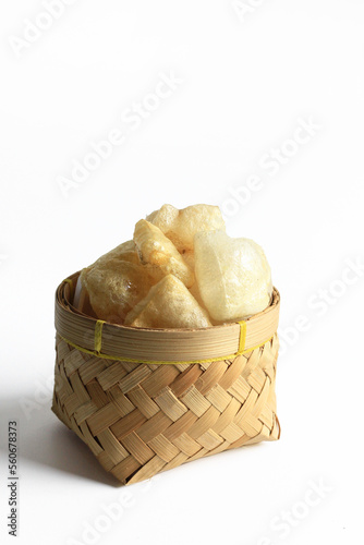 Rambak or Karupuak Jangek or Kerupuk Kulit  is a Indonesian Traditional Cattle or Cow Skin Cracker. Rambak in besek, isolated on white background. photo