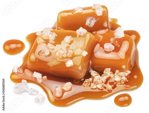 Salty caramel candies in milk caramel sauce with salt crystals isolated on white background. photo