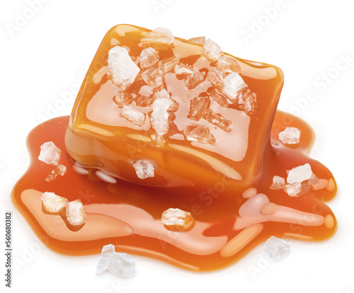 Salty caramel candy in milk caramel sauce with salt crystals isolated on white background.
