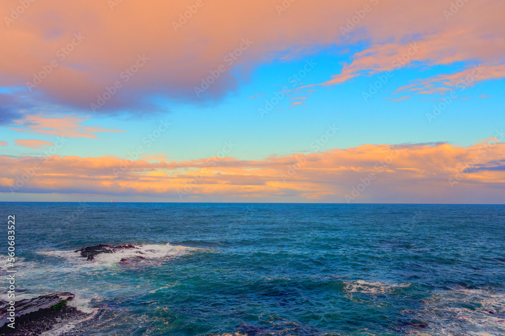 Rocky shore under blue sky and white clouds. White waves and moving white clouds Waimushan Seaside Scenic Area, Keelung, Taiwan