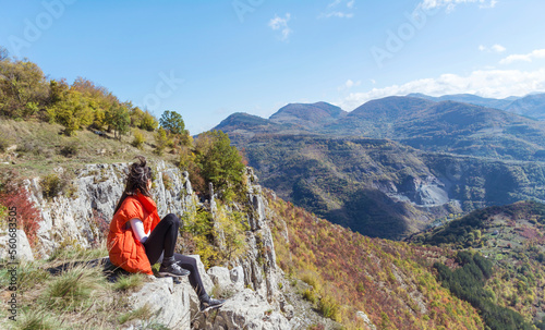 Traveler Woman sitting on a rocks in the autumn mountain . Balkan mountains, ,Bulgaria