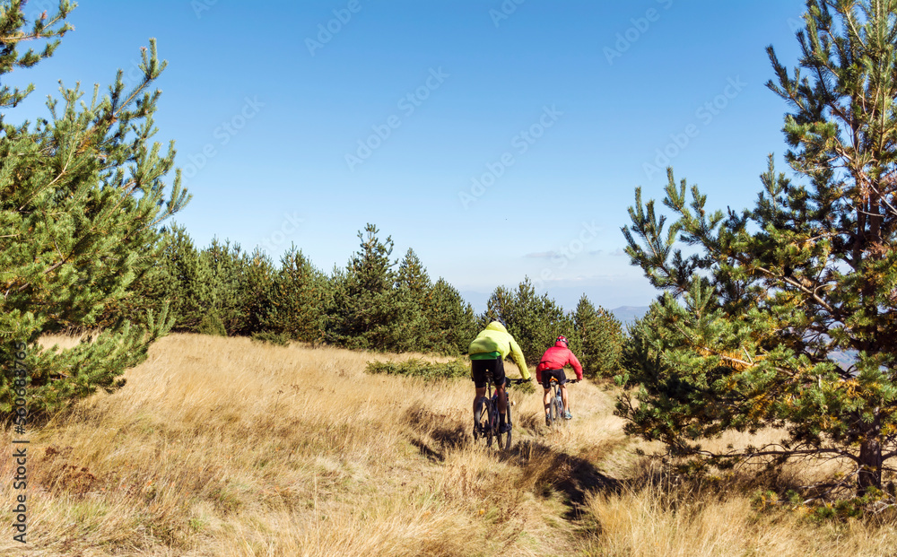 Two men cyclist biking on mountain path on mountain bike