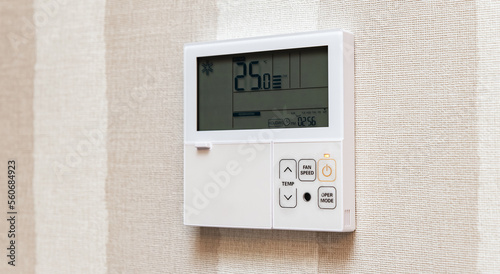 Close-up electronic thermostat on a white wall