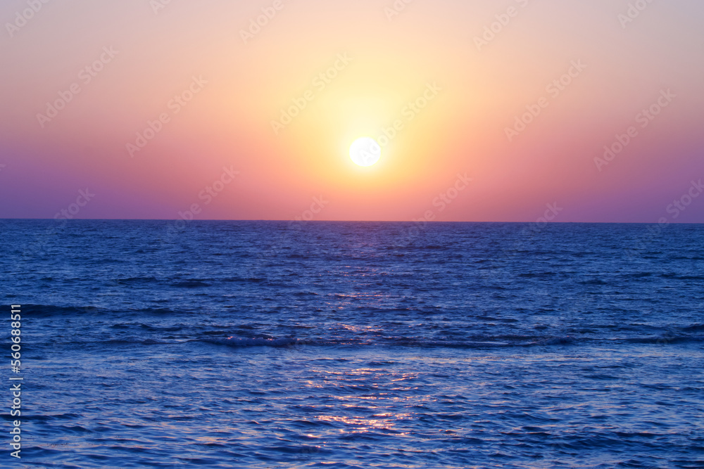 Fototapeta premium Sunset on beach. Sunset with ocean blue water, sky.