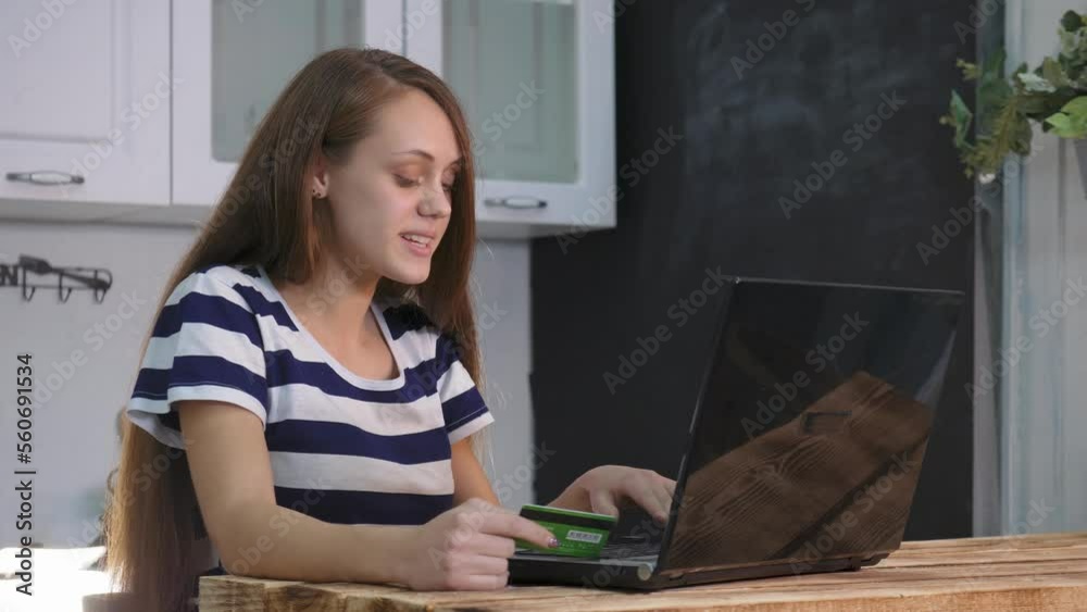 Woman using bank credit card for shopping in an online store. Shopping online store using laptop. girl makes purchases sitting at home via Internet, pays with credit card. concept of online shopping Woman using bank credit card for shopping in an online store. Shopping online store using laptop. girl makes purchases sitting at home via Internet, pays with credit card. concept of online shopping