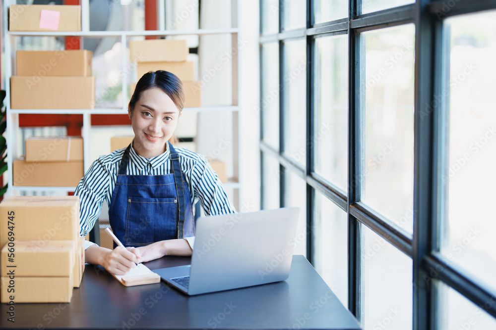 Starting small business entrepreneur of independent Asian female online seller packing products to send to customers and SME delivery concept