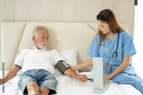 Man being cared for by a private Asian nurse at home suffering from Alzheimer's disease to closely care for elderly patients with copy space on left